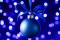 Blue christmas ball and blured purple lights at the background Royalty Free Stock Photo