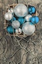 blue Christmas balls and silver, beads lie in a wooden basket to Royalty Free Stock Photo