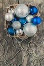 Blue Christmas balls and silver, beads lie in a wooden basket to Royalty Free Stock Photo