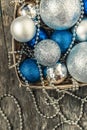 Blue Christmas balls and silver, beads lie in a wooden basket to Royalty Free Stock Photo