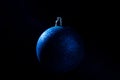 Blue Christmas bauble over dark background. Low key photo. Ball shape. Royalty Free Stock Photo