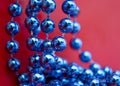 Blue Christmas Beads, Garland on Red. Abstract Background Royalty Free Stock Photo