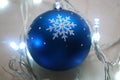 Blue christmas ornament surrounded by garland in cold tones. Royalty Free Stock Photo