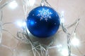 Blue christmas ornament surrounded by garland in cold tones. Royalty Free Stock Photo