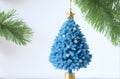 A blue Christmas tree is decorated with silver snowflakes and a gold star.The image is both festive and elegan, , and it is