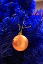 Blue christmas tree with yellow bulb. Blue artificial pine tree branch with golden ball. Festive happy new year decoration. Royalty Free Stock Photo