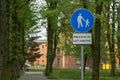 Blue circular shape road sign for pedestrians and cyclists in the city park. Caption below sign: Cycling is allowed. Royalty Free Stock Photo