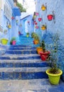 Blue city street with colorful flower pots Royalty Free Stock Photo