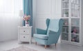 Blue classic armchair and white drawer cabinet with table lamp and flowers vase in white room Royalty Free Stock Photo