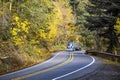 Blue classic bonnet American big rig semi truck with chrome accessories driving cargo in low profile bulk semi trailer driving on Royalty Free Stock Photo