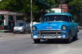 A blue classic car drived on the street in havana city