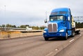 Blue classic powerful big rig semi truck with high cab and flat Royalty Free Stock Photo