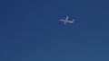 In the blue clear sky, a plane taking off is gaining altitude Royalty Free Stock Photo