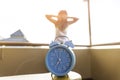 Blue clock and back view young woman ,she is relax time and stretch the muscles on a balcony Health concept