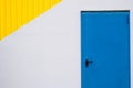 Blue close metal door on a white and yellow wall Royalty Free Stock Photo