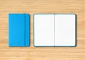 Blue closed and open lined notebooks on wooden background Royalty Free Stock Photo