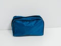 Blue cloth bag, cosmetic bag with black zipper stands on white table. Medical bag, first aid kit