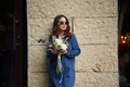 In blue clothes. Beautiful woman is with flowers in hands outdoors Royalty Free Stock Photo