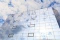Blue clouds and sun are reflected in the glasses of windows of a modern building. Right view Royalty Free Stock Photo