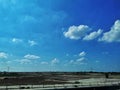 Blue cloudy sky with dirt plain wallpaper. Print ready photo