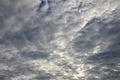 A blue cloudy sky with many small clouds blocking the su Royalty Free Stock Photo