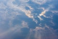 Blue cloudy sky in the mid-day, with sun covered by the cloud and God rays Royalty Free Stock Photo