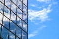 Blue cloudy sky reflected by mirror panes in modern building making an abstract image - room for copy Royalty Free Stock Photo