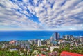 Blue coast of Black Sea in Sochi city with residential houses and recreation areas under summer cloudy sky