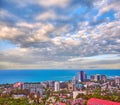 Blue coast of Black Sea in Sochi city with residential houses and recreation areas under summer cloudy sky