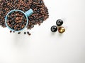 Blue coffee cup, with coffee beans surrounding, three coffee capsules, with white background. Top view Royalty Free Stock Photo