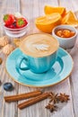 Blue coffee cup with cappuccino, cinnamon and anise. Breakfast concept