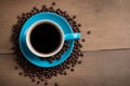 A blue coffee cup full of black coffee on a wood background with coffee beans Royalty Free Stock Photo