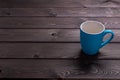 Blue coffee Cup on a wooden table on a brown orange background Royalty Free Stock Photo