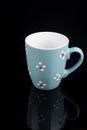 Blue coffee mug isolated above black background with reflections Royalty Free Stock Photo