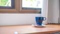 Blue coffee mug is placed beside the window in the morning, Relax time, Fresh weak up Royalty Free Stock Photo