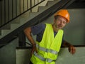 Blue collar job lifestyle. Portrait of tired and exhausted construction worker in helmet and vest at building site complaining of Royalty Free Stock Photo