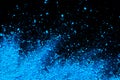 Blue color background of chalk powder. Blue color dust particles splattered on black background Royalty Free Stock Photo