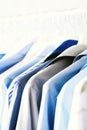 Blue color clothes. Male clothes, jackets and shirts hanging on clothes rail. Copy space. Banner Royalty Free Stock Photo