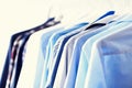 Blue color clothes. Male clothes, jackets and shirts hanging on clothes rail. Copy space. Banner Royalty Free Stock Photo