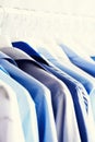 Blue color clothes. Male clothes, jackets and shirts hanging on clothes rail. Copy space. Banner Royalty Free Stock Photo