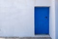 Blue color door on a white wall, greek island architecture, copy space Royalty Free Stock Photo