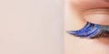 Blue color eyelash extensions. Trendy false lash style close-up, closed eye macro. Wide banner or background with copy space Royalty Free Stock Photo