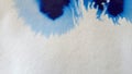 Blue color inks spreading out over wet paper background.