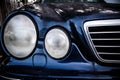 A blue color matte Mercedes-Benz W208. Bumper and oval headlights of luxury car