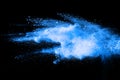 Blue color powder explosion cloud on black background.Closeup of Blue dust particles exhale on dark background Royalty Free Stock Photo