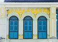 Blue color wooden arched window on green and yellow cement wall in chino Portuguese style at Phuket old town, Thailand Royalty Free Stock Photo
