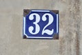 A blue colored house number plaque, showing the number thirty two Royalty Free Stock Photo