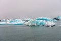 Blue colored melting icebergs floating around in Jokulsarlon glacier lagoon in Iceland during foggy weather. Royalty Free Stock Photo