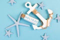 Blue colored summer and vacation background, anchor, sea stars and a glass bootle with the word holiday, travel and tourism Royalty Free Stock Photo