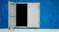 Blue colored wood wall with old white wooden window Royalty Free Stock Photo